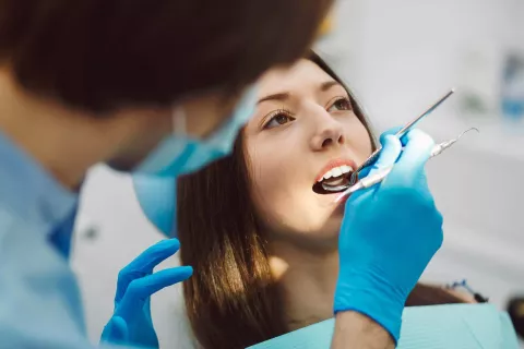 Dentist examining an adult's mouth.