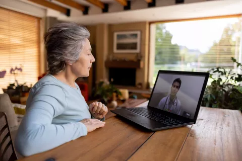 A senior on a video call with a doctor in their living room.