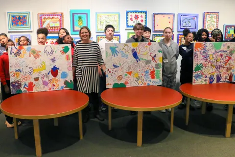 A group of kids display some artwork