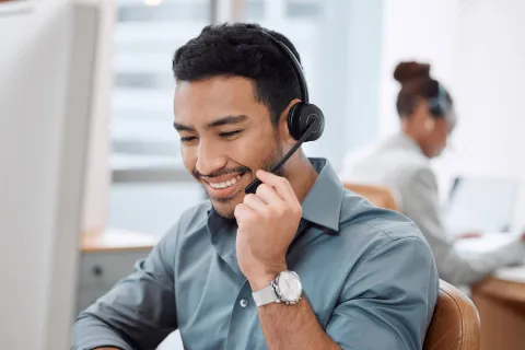 Adult adjusting the microphone on their headset, smiling.