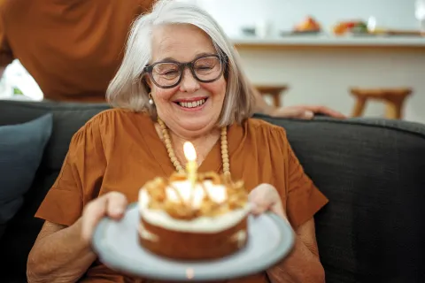 Senior woman holding Birthday cake