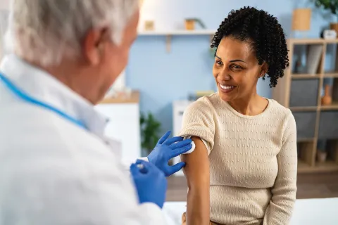A Woman is about to receive a vaccine.