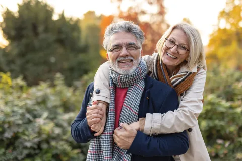 A couple smiles outdoors