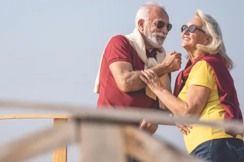 A couple enjoys the sun with sunglasses. 