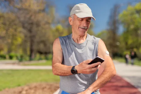 A man checks his blood sugar using a continuous blood glucose monitor.