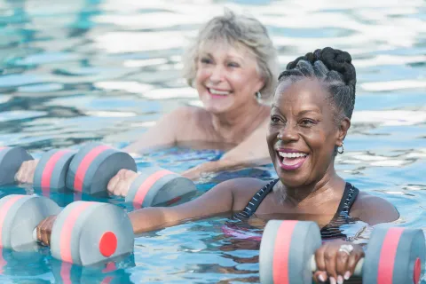 Two women workout in a pool.