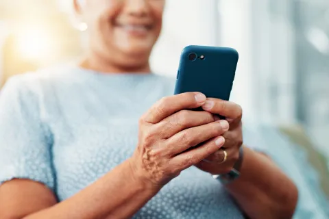 Person typing on phone and smiling