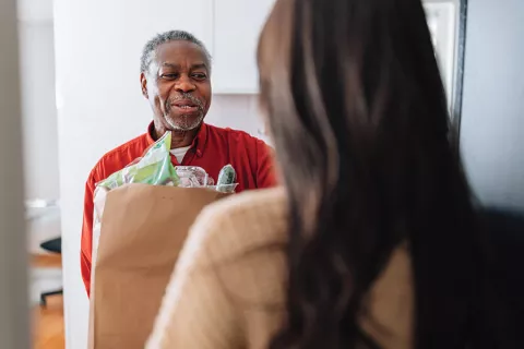 A man delivers a bag of groceries.