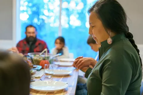 A woman prays before a meal.