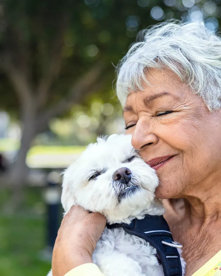Senior adult holding a small dog.