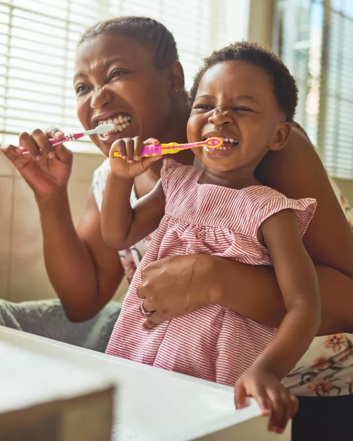 Un adulto y un niño cepillándose los dientes.