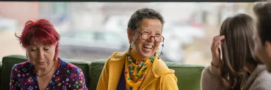 Women laugh with books in their hands.