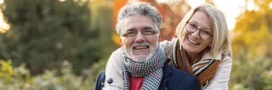 A couple smiles outdoors