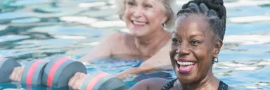 Two women workout in a pool.