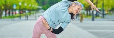 A woman stretches in a a park.